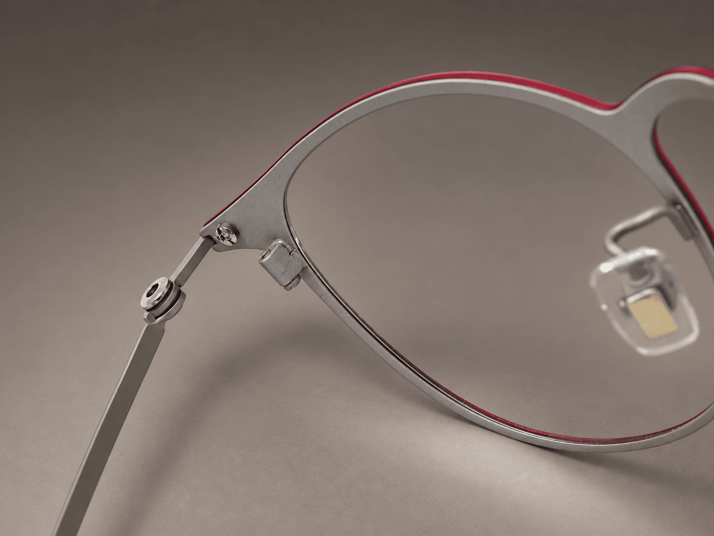 S-L7026 inner circular hinge, screw and silver-tone reverse rim of the crimson titanium frame.