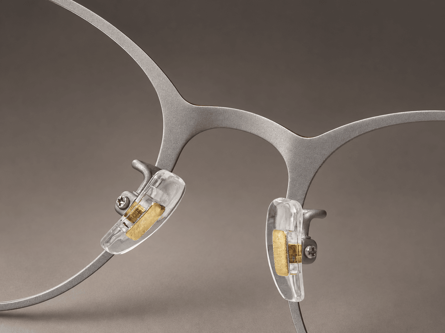 S-L7026 silver-tone inner bridge contrasting with the crimson outer edge, with clear nose pads.