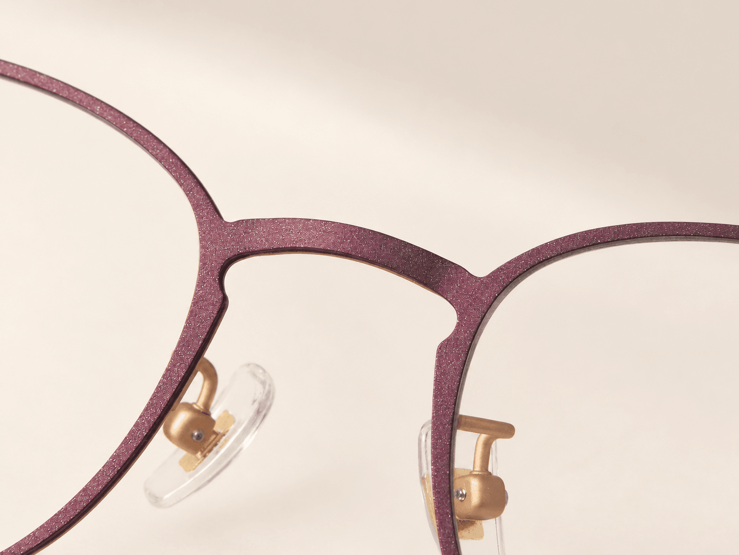 Macro view of the fine-grained plum finish across the front bridge and rims.
