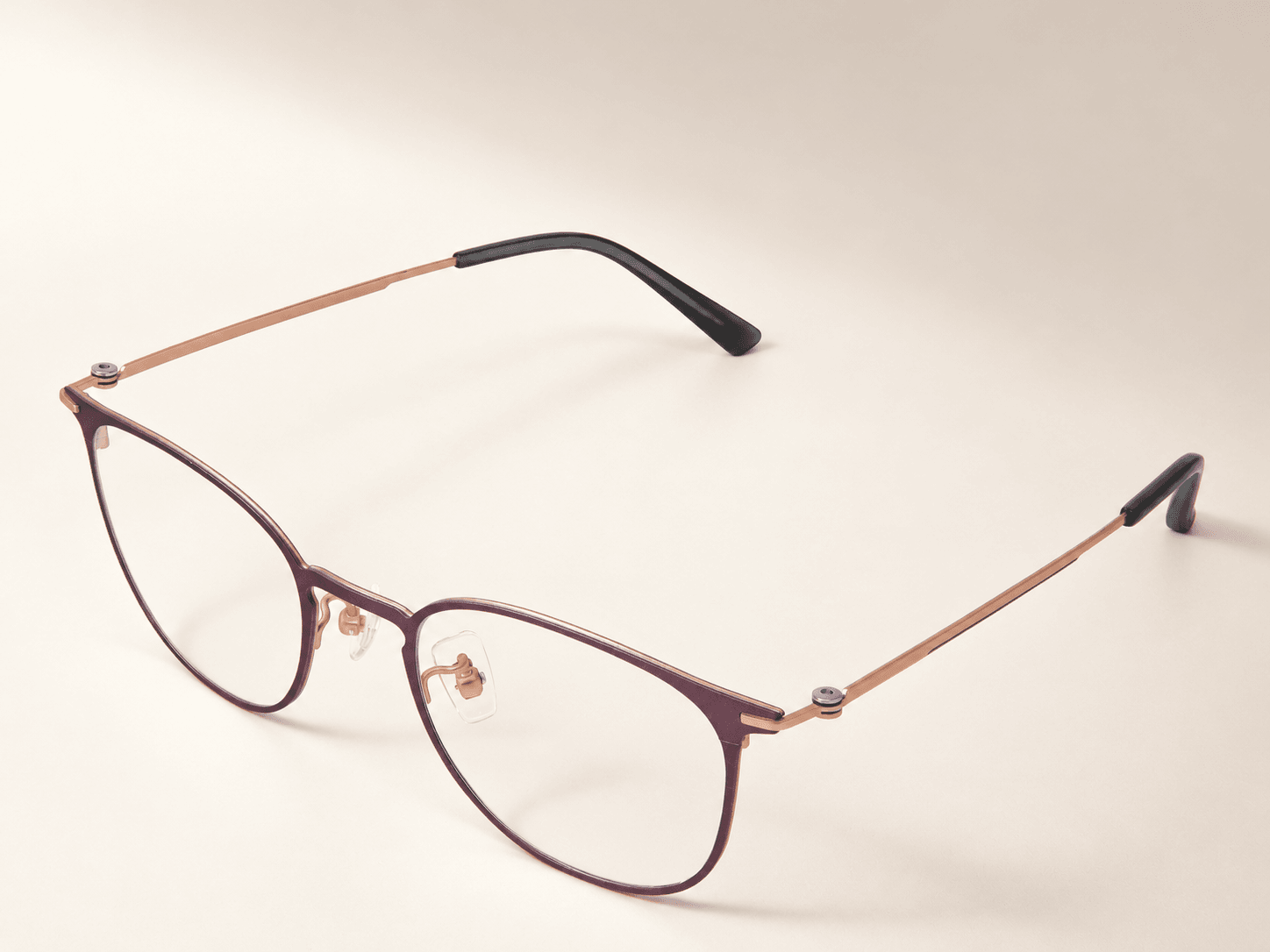 Three-quarter view of the complete plum titanium optical frame with both temples open.