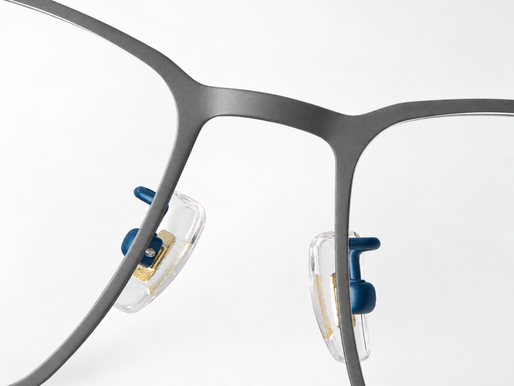 S-L7020 satin graphite-grey front bridge with blue nose-pad supports and clear pads.